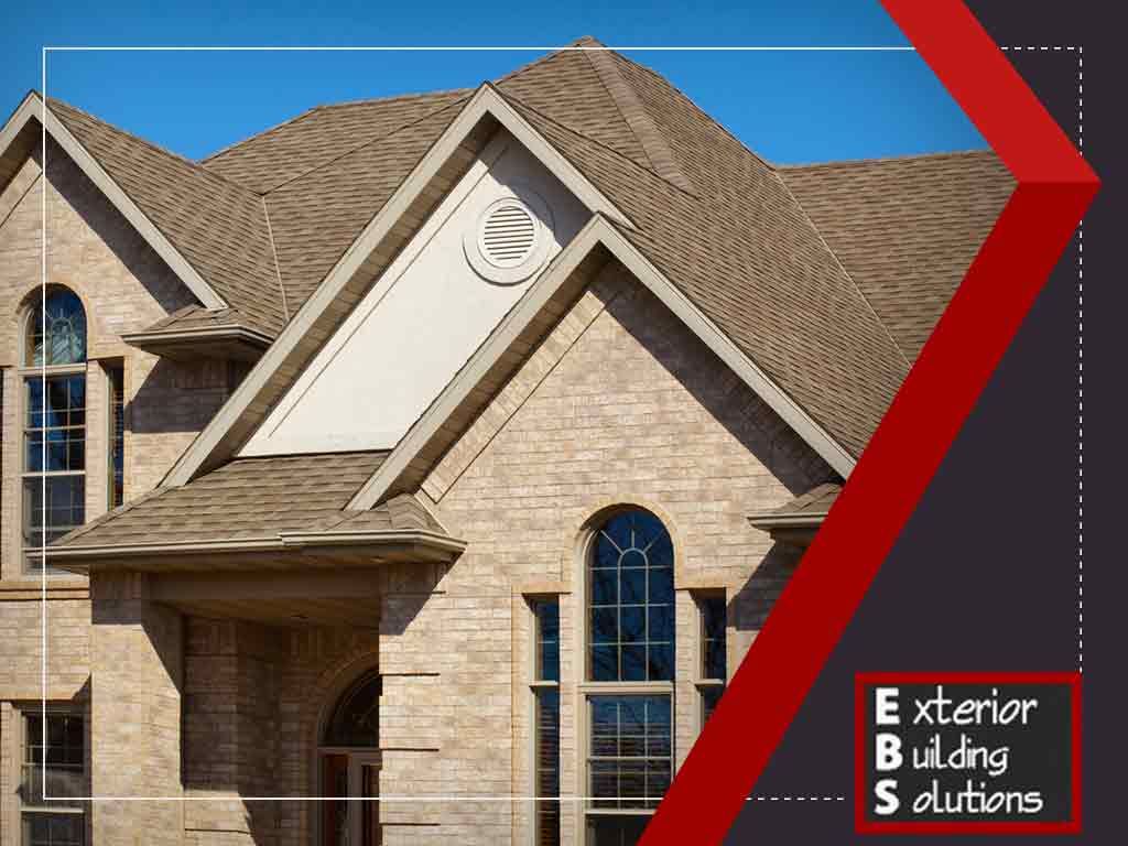 Steep brown shingle roof on a brick home, showing why proper steep roof installation matters