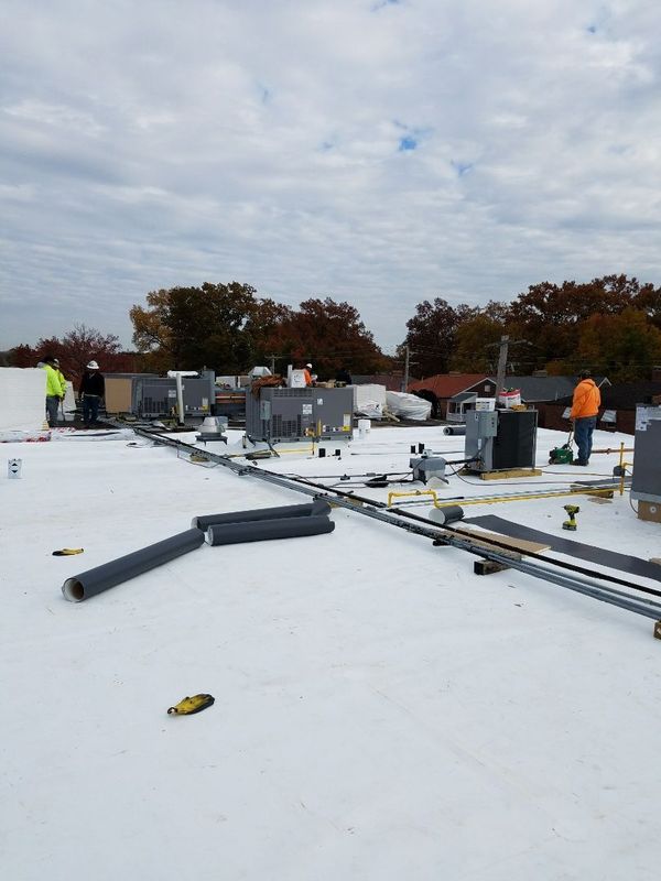 Low-slope white commercial roof with rooftop equipment