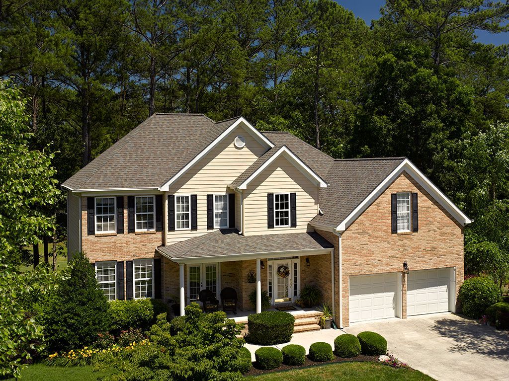 Shingle roof protecting a two-story brick suburban home